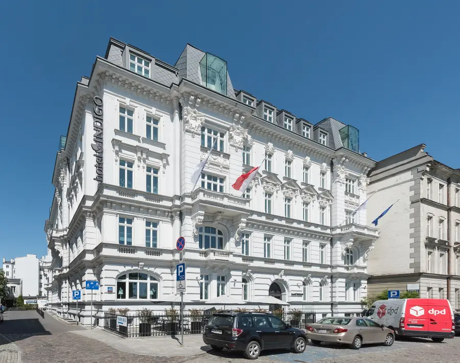 Biała, bogato zdobiona kamienica przy Smolnej 40 z pionowym napisem hotel Indigo na narożniku